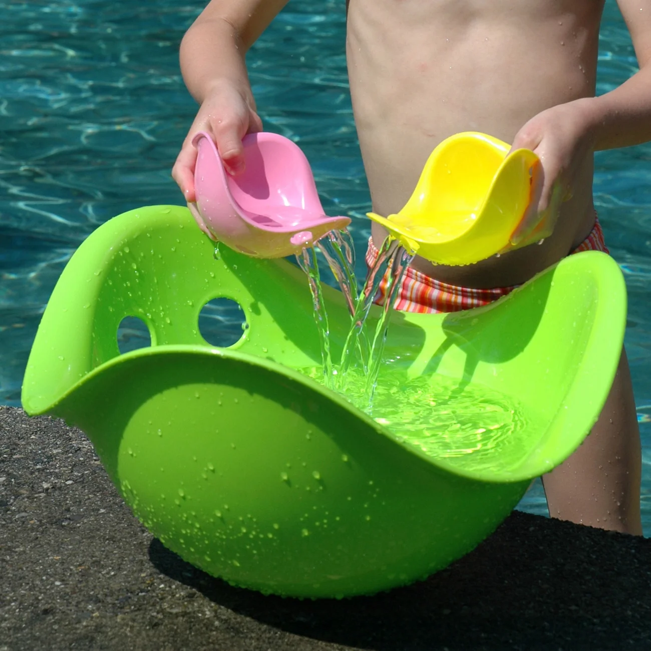 MOLUK Bilibo · Classic 12-piece assortment — Green Bilibo and Mini shells during supervised pouring play.